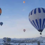 Paisaje nevado de Capadocia con globos volando