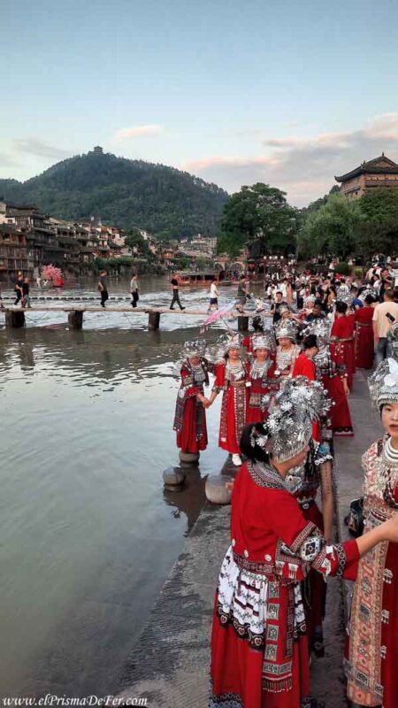 Muchos turistas chinos con trajes tradicionales de la etnia Miao